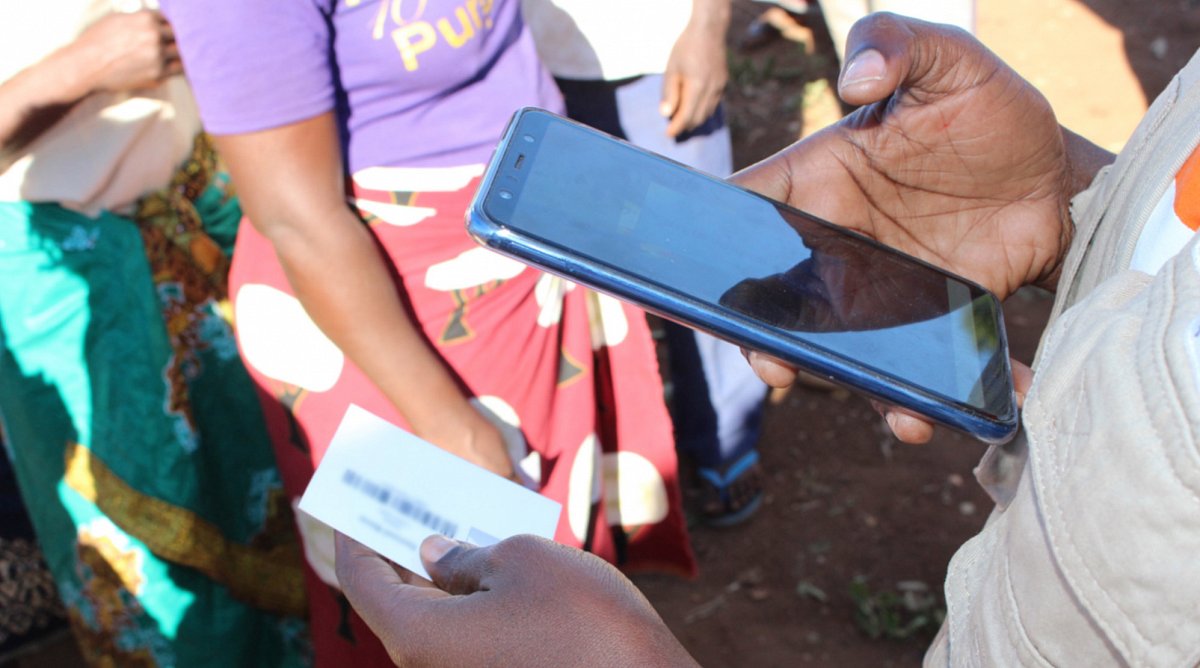 Mozambik: Ein Mitarbeiter von World Vision scannt mit seinem Mobiltelefon eine ID-Karte.