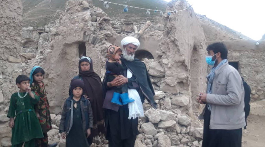 Afghanistan : personnes devant un bâtiment détruit après le séisme.