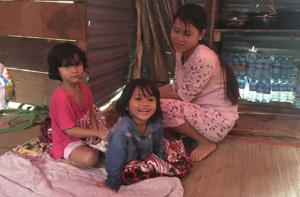 Vietnam: Eine Mutter kümmert sich in einer Notunterkunft um ihre beiden Töchter.