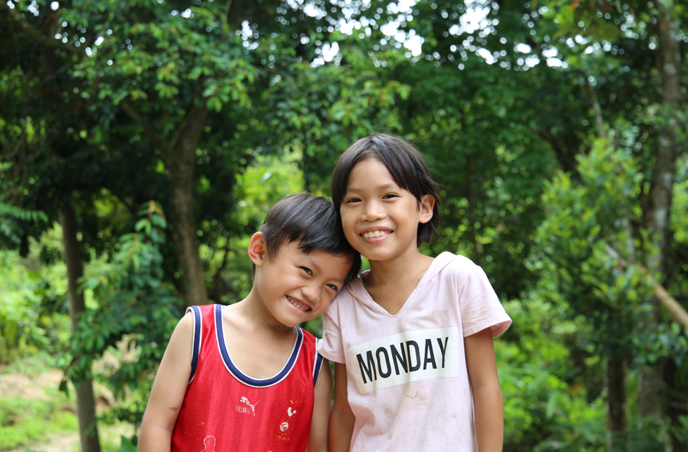 Vietnam: Ein Mädchen und ein Junge lächeln in die Kamera.