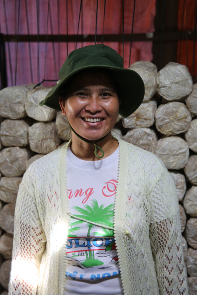 Vietnam: Frau mit Hut lächelt in die Kamera.