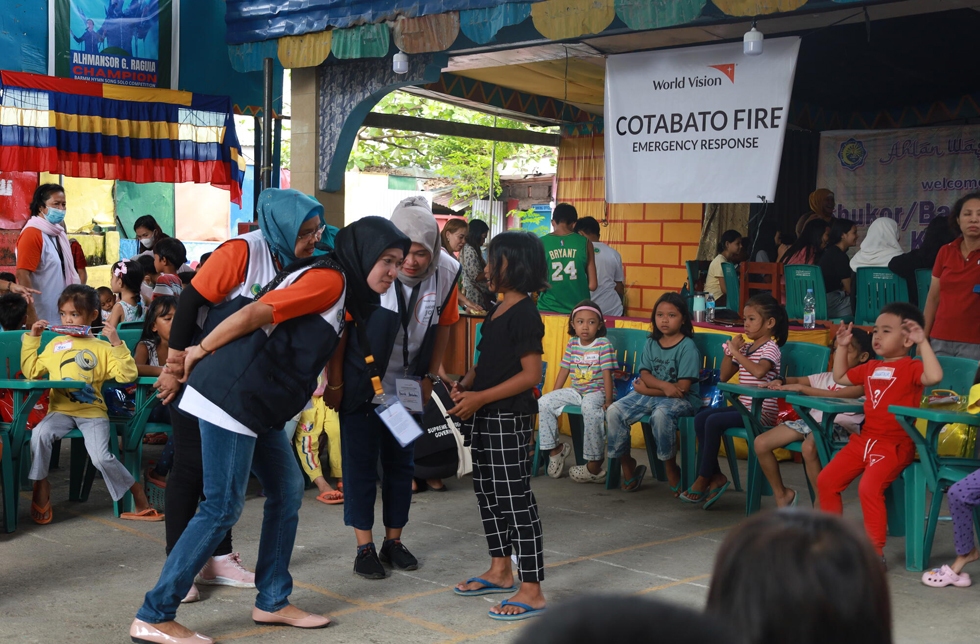 Philippines : Collaboratrices de World Vision et enfants dans un Child-Friendly-Space.