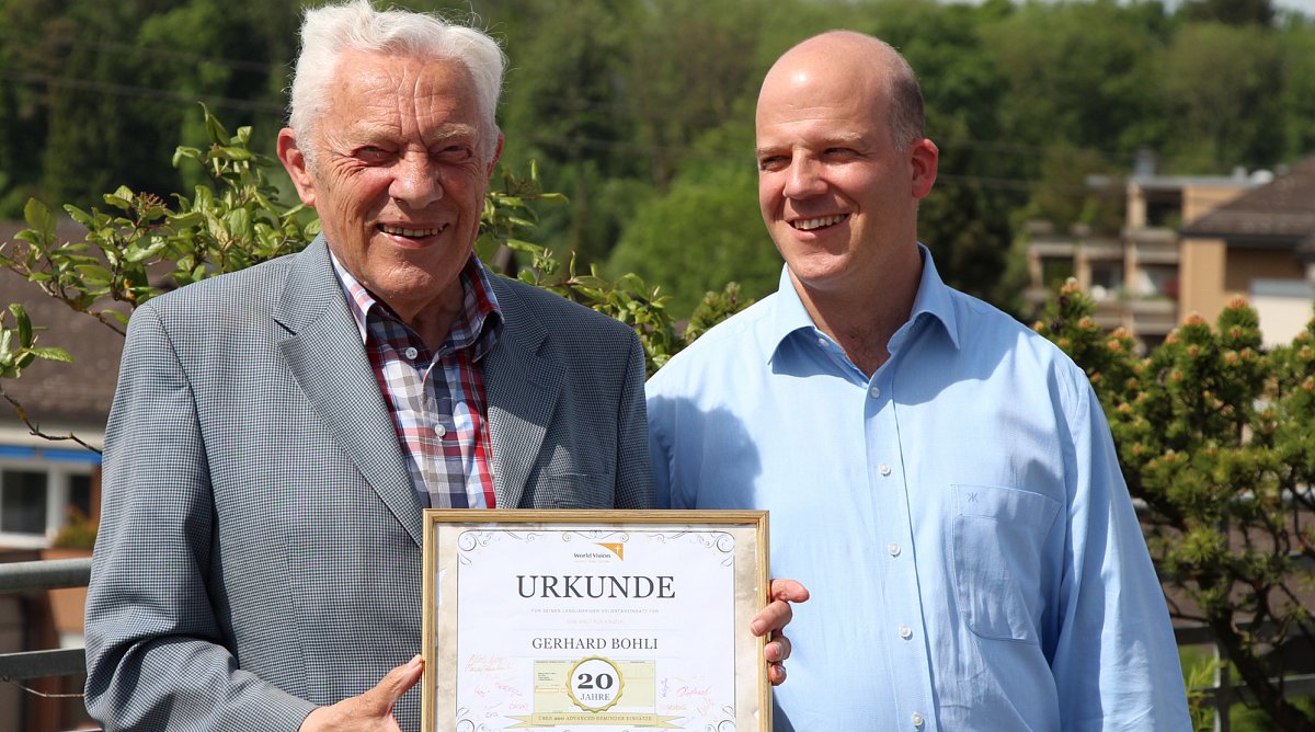 Reto Gerber, CEO / Geschäftsführer von World Vision Schweiz, überreicht Gerhard Bohli eine Urkunde für seinen langjährigen Einsatz für «EINE WELT FÜR KINDER».