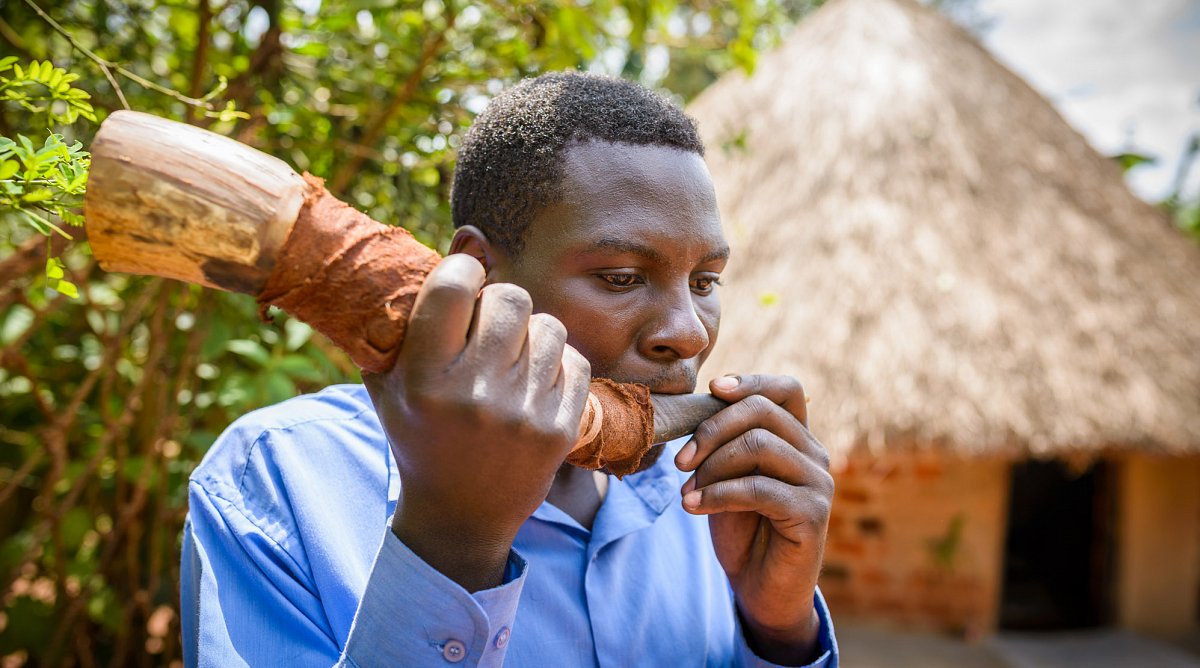 Nicht alle traditionellen Heiler opfern Kinder. Kibogo setzt sein Horn dazu ein, das Dorf bei einer Kindsentführung zu warnen und unterstützt so den Kampf gegen Kinderopfer.