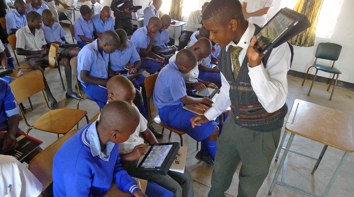 Schüler bei der Benützung der iPads in Simbabwe