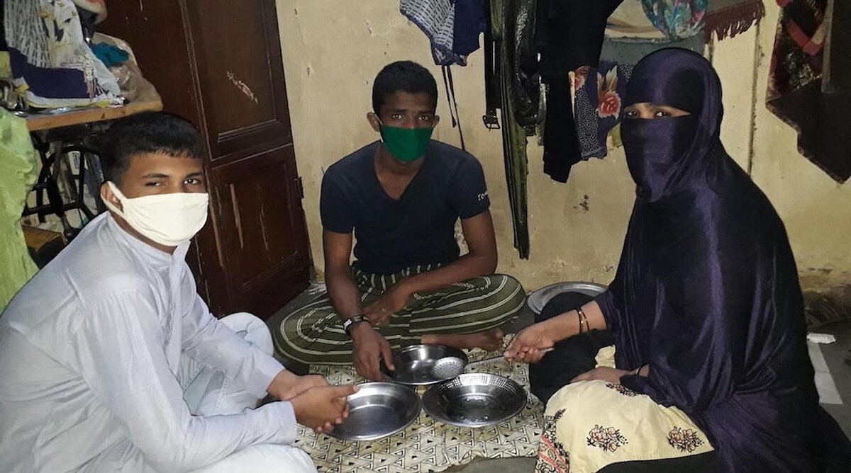 Von links nach rechts: Sufian, Sohail und ihre Mutter Nilofer beim Essen in ihrer Wohnung.