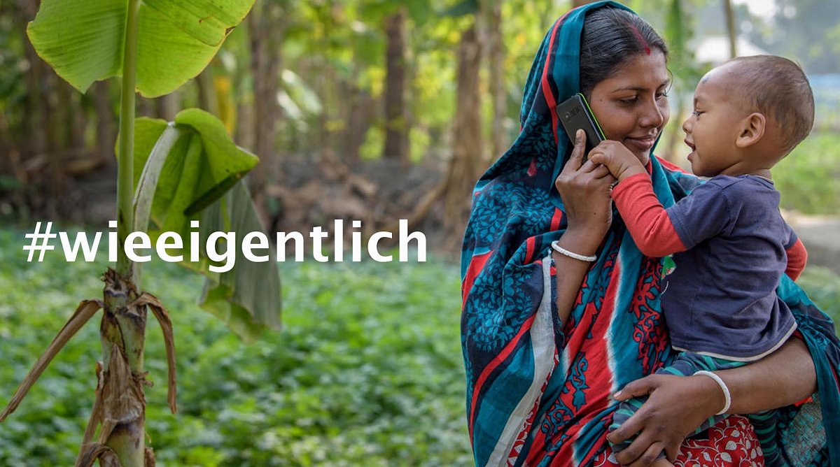 Bangladesch:Eine Mutter hält ein Baby auf dem Arm, dass nach dem Handy an ihrem Ohr greift.