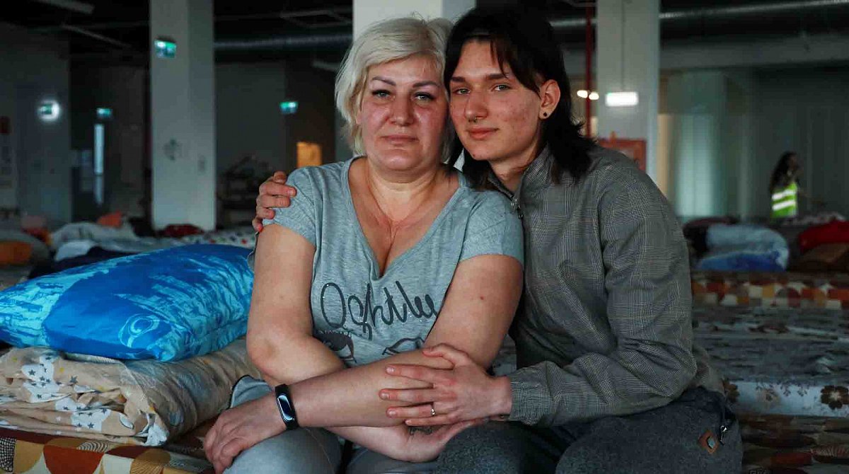 Ukraine: Ein junger Mann sitzt neben seiner Mutter.