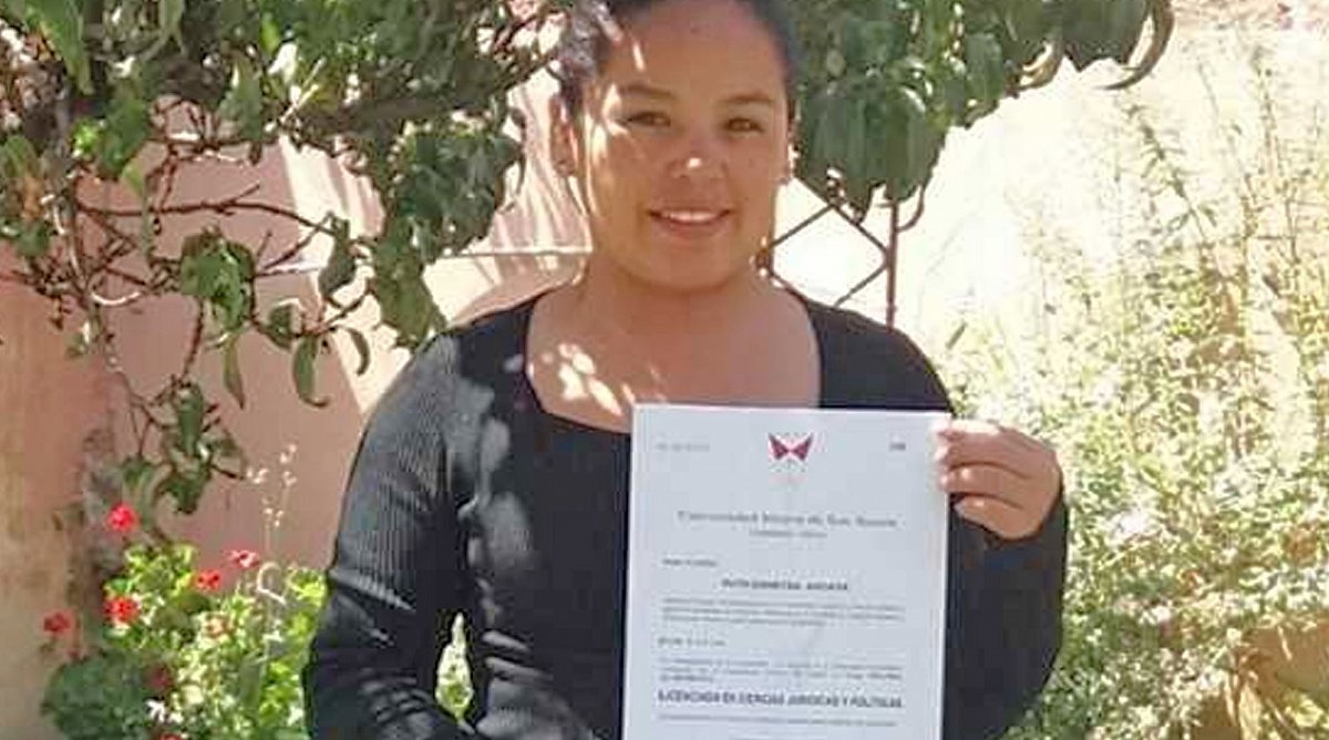 Junge Frau aus Bolivien hält Zertifikat.