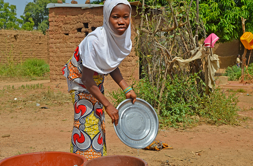 Ein Mädchen beim abwaschen in Diago, Mali