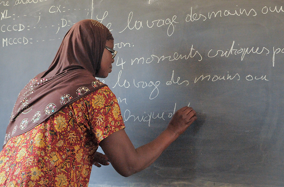 Eine Lehrerin schreibt an die Wandtafel in Neguela, Mali
