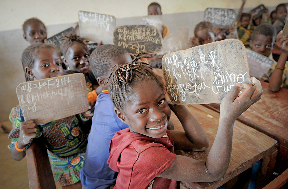 Kinder zeigen ihre Schreibübungen in Neguela, Mali