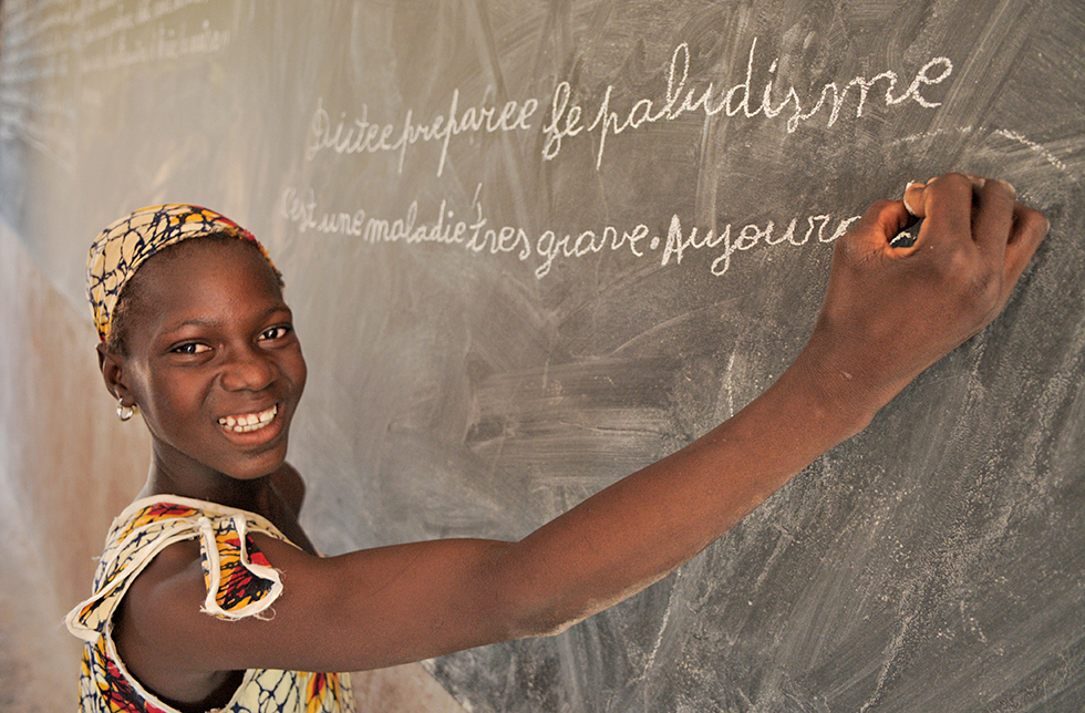 Ein Mädchen schreibt an die Wandtafel im Klassenzimmer in Seniwe, Mali 
