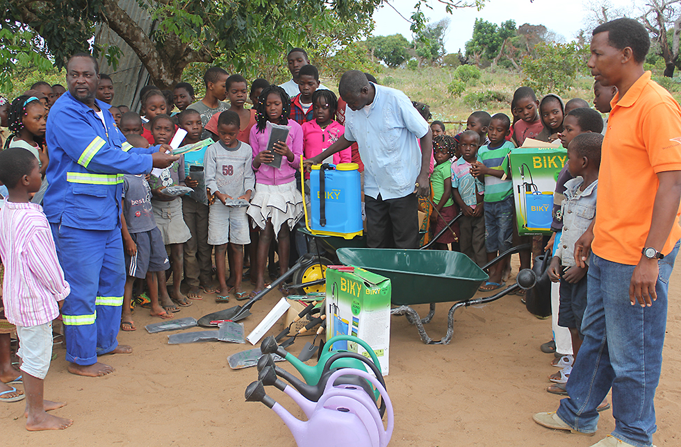 Eine Gruppe Menschen bereitet sich auf die Bearbeitung der Felder in Ukane, Mosambik, vor 