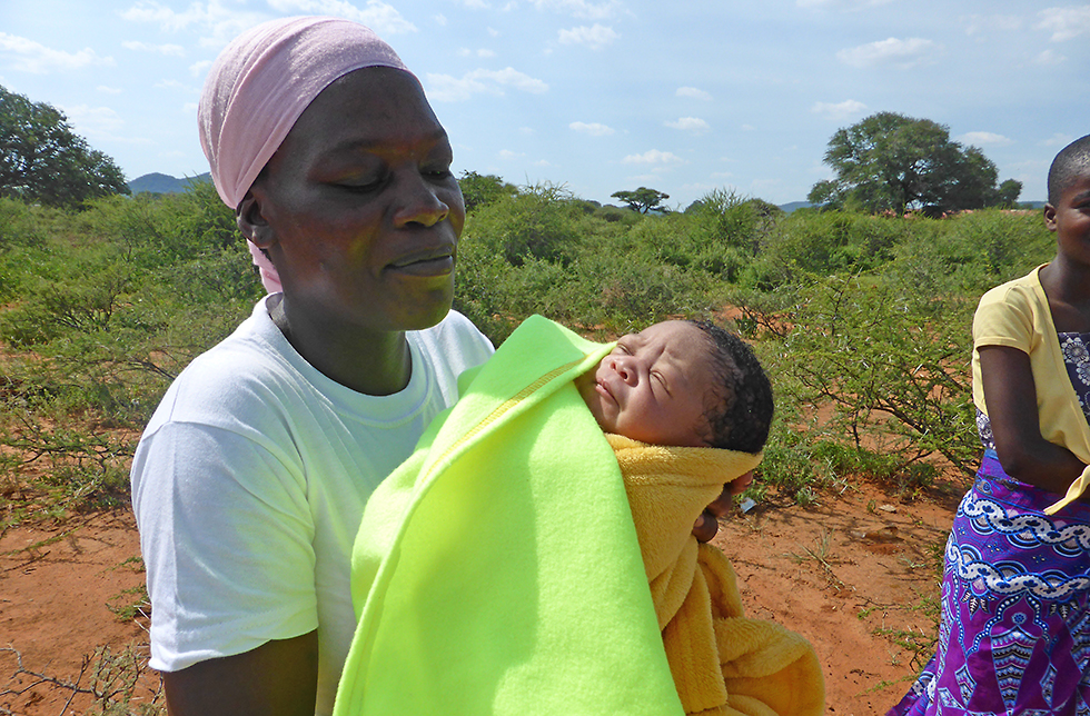 Ein Baby wird von einer Gesundheitshelferin getragen in Matobo Kezi, Simbabwe
