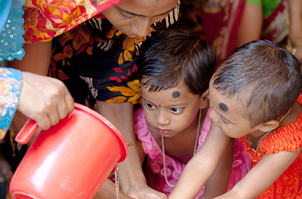 Zwei kleine Mädchen beim Händewaschen in Ghoraghat, Bangladesch