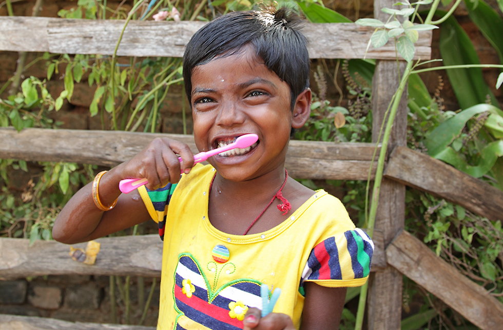 Ein Mädchen putzt sich die Zähne, Khariar, Indien