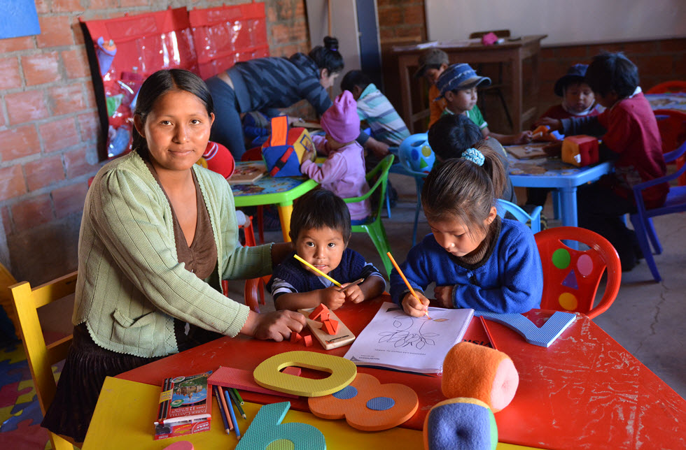 Eine Lehrerin unterrichtet Kinder in einem Schulhaus
