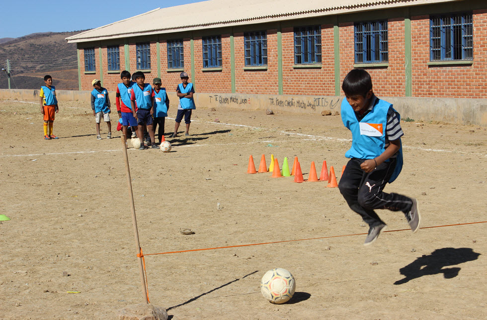 Eine Gruppe von Schülern spielt ein Ballspiel in einer Schule in Lomas, Bolivien 