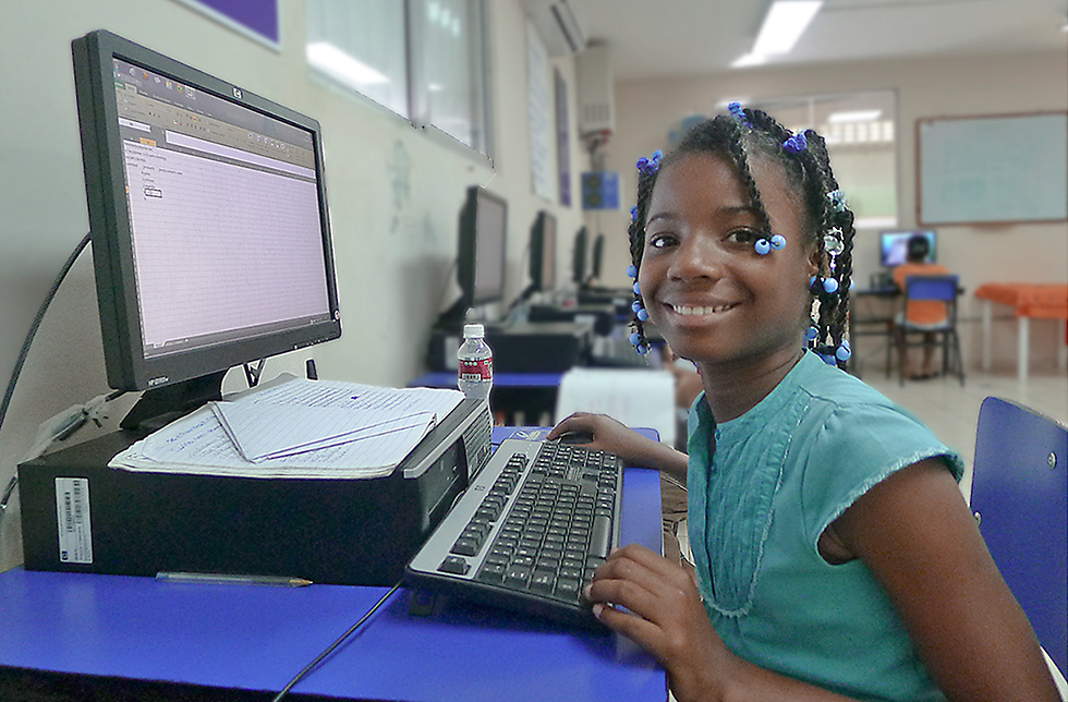 Ein Mädchen bedient einen Computer in Canaan, dominikanische Republik