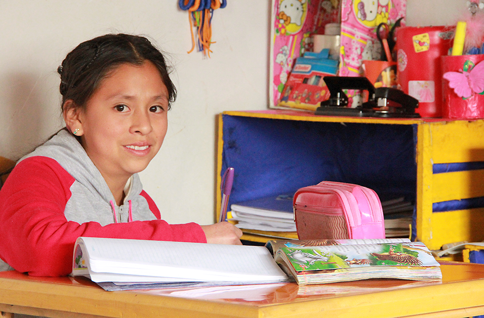 Mädchen in ihrer eigenen Hausaufgabenecke in Querococha, Peru