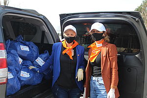 Zwei Frauen vor einem Wagen mit Hilfsgütern in Georgien.