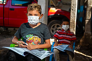 Zwei Jungen in Honduras lernen im Lockdown mit Studienbüchern.