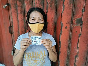 Philippinen: Eine Frau erhält Geld von einem World Vision-Projekt.
