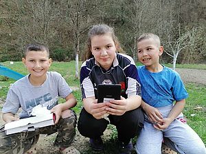 Drei Kinder mit einem Tablet in Bosnien-Herzegowina