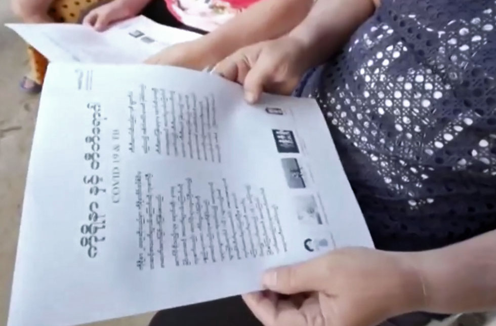 Thailand: Auf einem Blattpapier stehen wichtige Informationen bezüglich COVID-19, die vom Thailändischen ins Myanmarische übersetzt wurden.