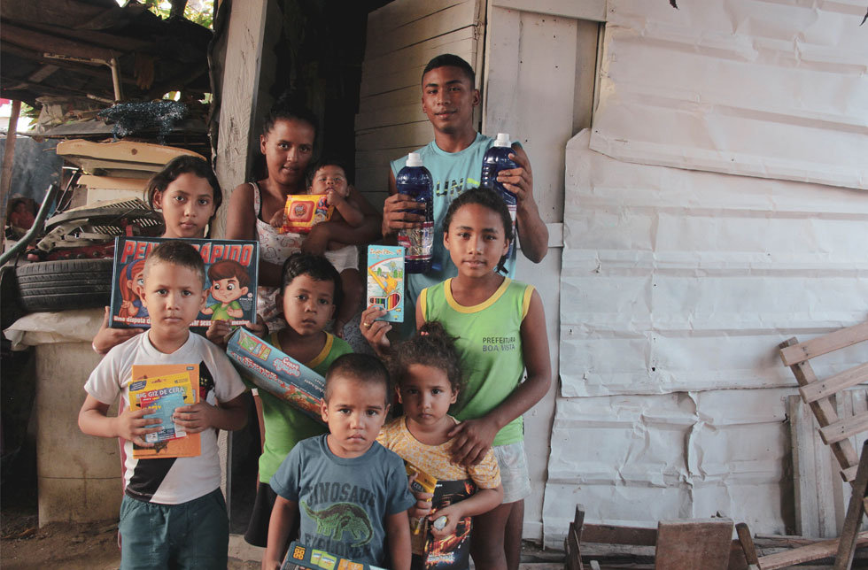 Brasilien: Eine Familie zeigt die Lernmaterialien, Spielsachen und Hygieneartikel, die sie von World Vision erhalten haben.