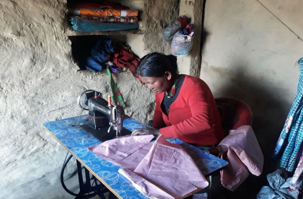 Jumla Sinja, Nepal: Eine Frau näht Kleidungstücke mit ihrer eigenen Nähmaschine.