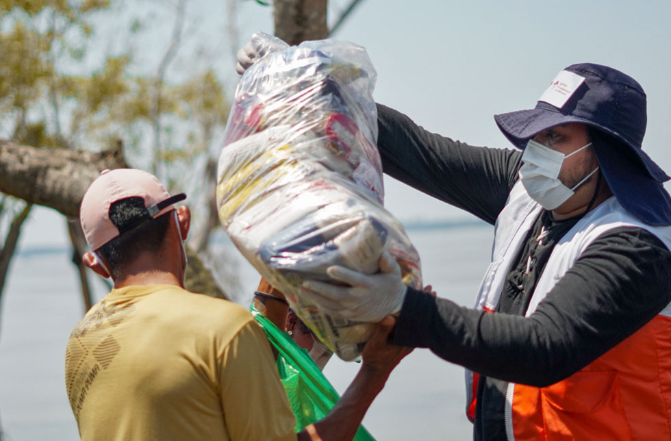 Amazonien, Brasilien: Ein Mitarbeiter von World Vision übergibt einem Mann ein Hilfspaket.