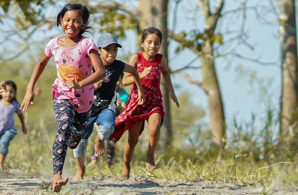 Amazonien, Brasilien: Eine Gruppe Kinder rennt fröhlich umher.