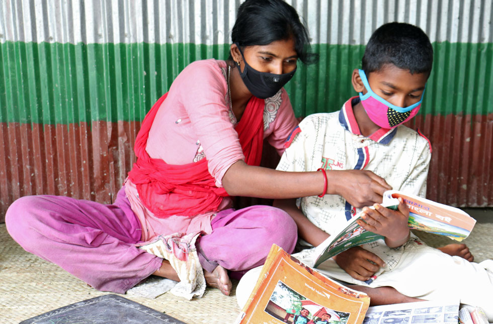 Bangladesch: Geschwister helfen sich beim Lernen.