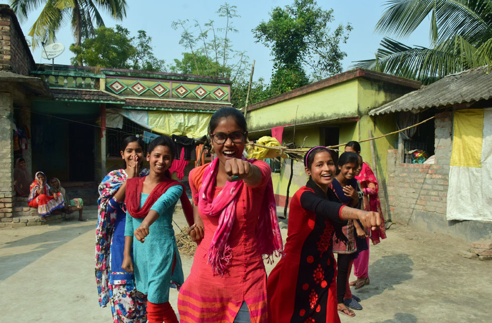 Indische Mädchen stehen lachend in Boxerhaltung, um Girls Power zu demonstrieren. 