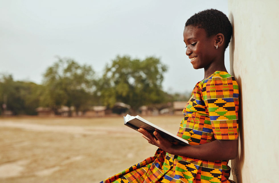 Ein Mädchen in Ghana liest ein Buch.
