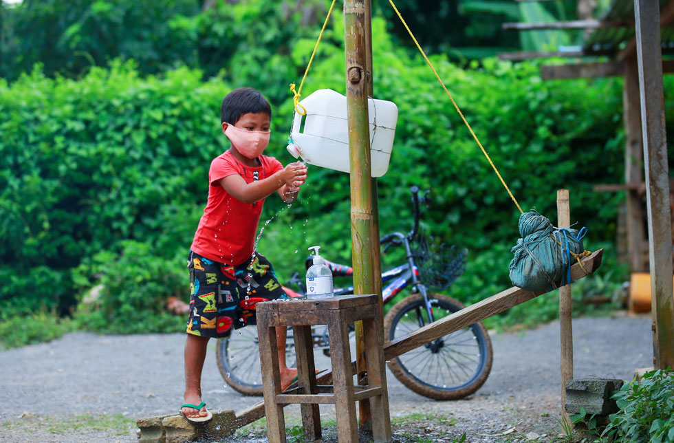 Myanmar: Ein Junge bedient ein Tippy Tap.