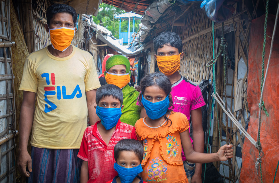 Eine Rohingya-Familie in einem Flüchtlingslager in Bangladesch trägt Schutzmasken.