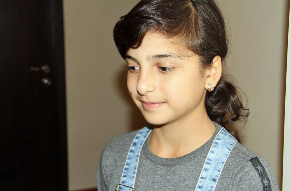 Armenien: Ein Mädchen trägt eine Latzhose und schaut nicht direkt in die Kamera.
