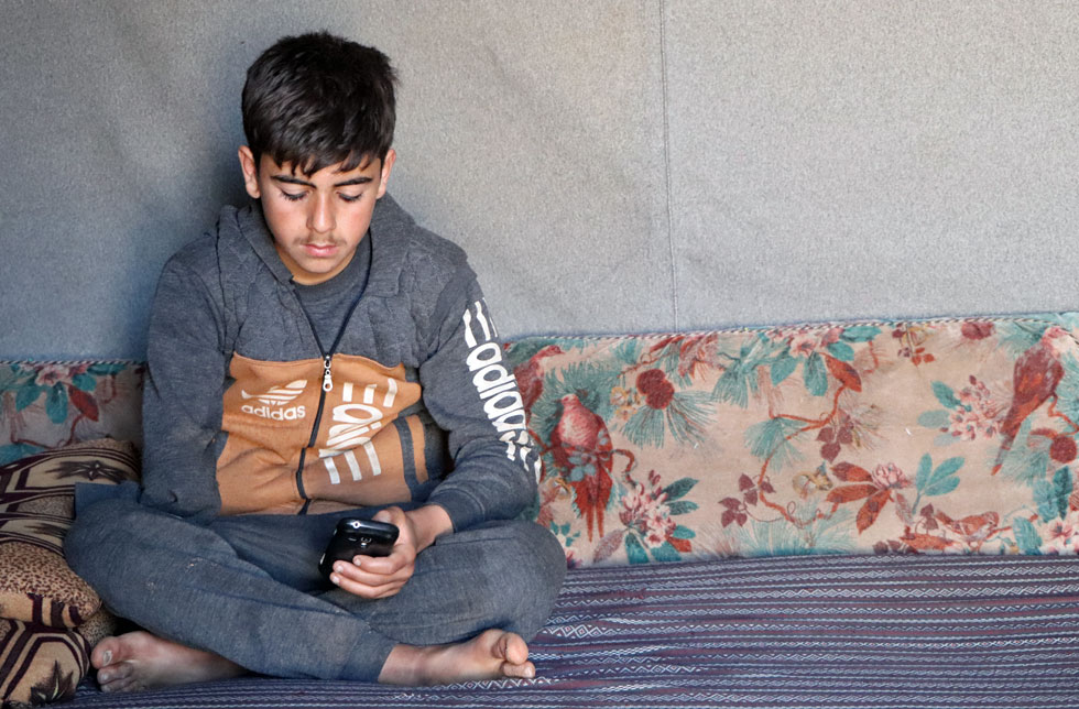 Syrien: Ein Junge spielt mit seinem Mobiltelefon.