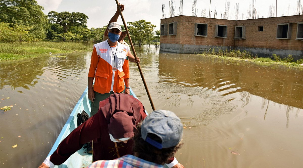Honduras: Ein World Vision-Mitarbeiter bringt von der Überschwemmung betroffene Familie mit einem Boot in Sicherheit.