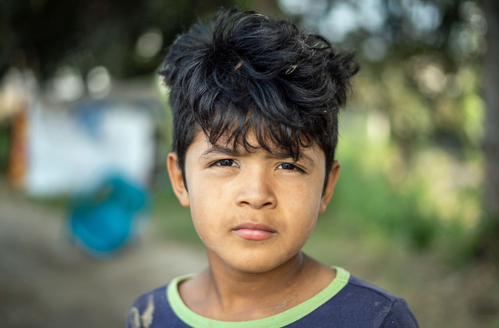 Honduras: Ein kleiner Junge blickt traurig in die Kamera. Er hat sein Zuhause verloren.