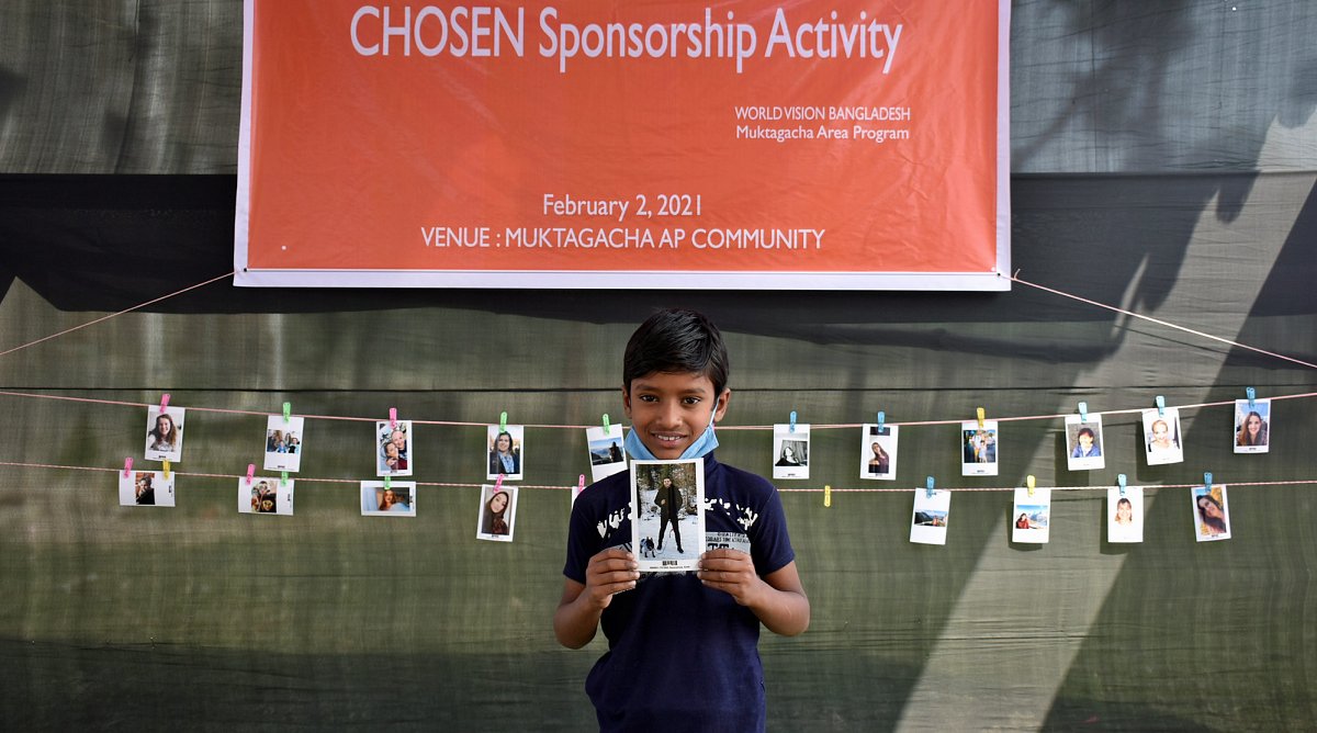 Bangladesch: Ein Patenkind hält am Chosen-Event das Foto seines Paten in den Händen.