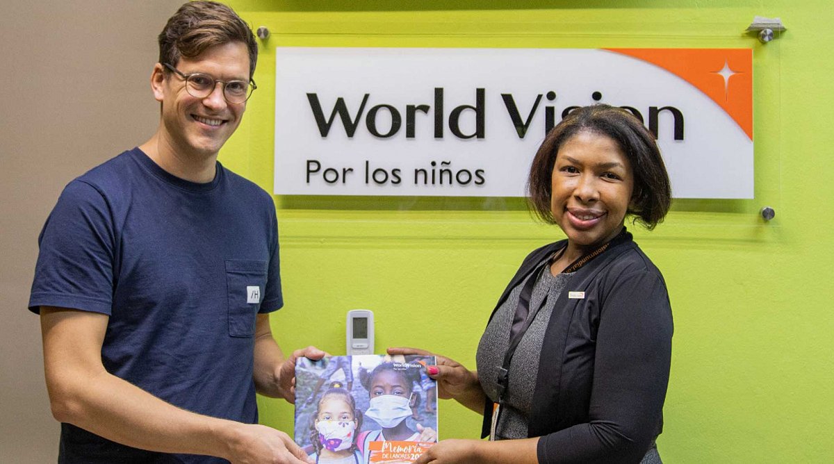 Dominikanische Republik: Ein Boardmember von World Vision Schweiz erhält einen Jahresbericht.