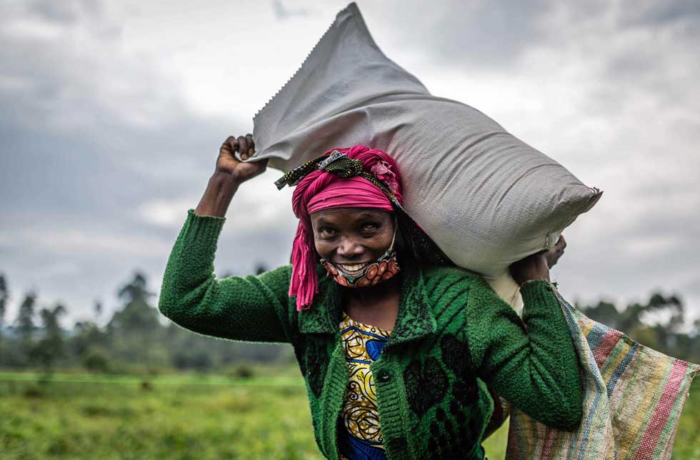 DRC: Eine Frau trägt einen Sack mit Nahrungsmitteln auf dem Kopf.