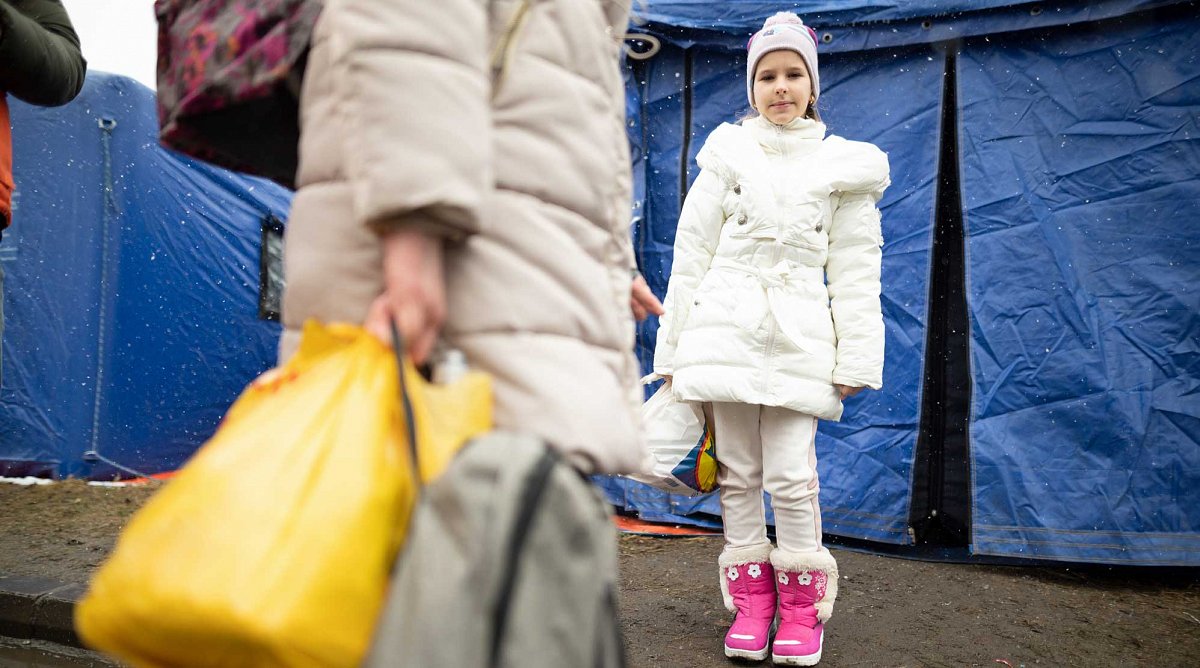 Ukraine: Ein Mädchen steht vor einem Flüchtlingszelt.