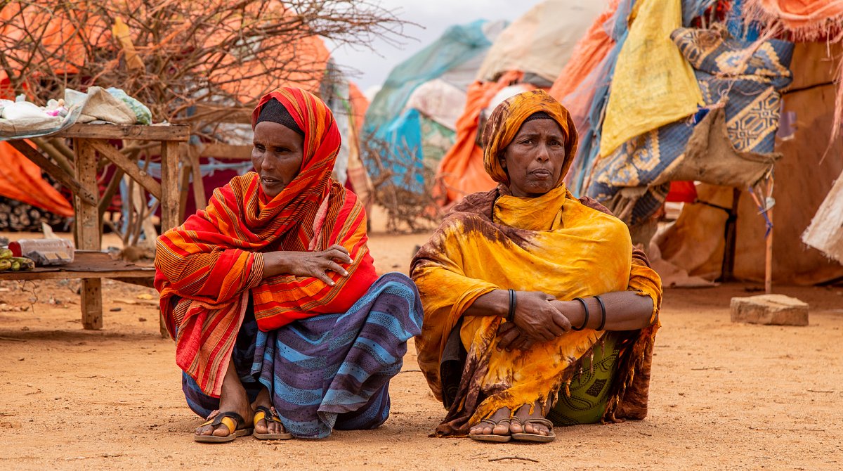 Somalia: Zwei Frauen sitzen auf dem Boden in einem Flüchtlingslager.