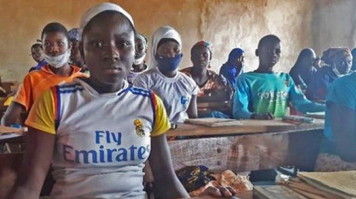Mali: Mädchen sitzt mit ihren Klassenkameradinnen und -kameraden im Schulzimmer.