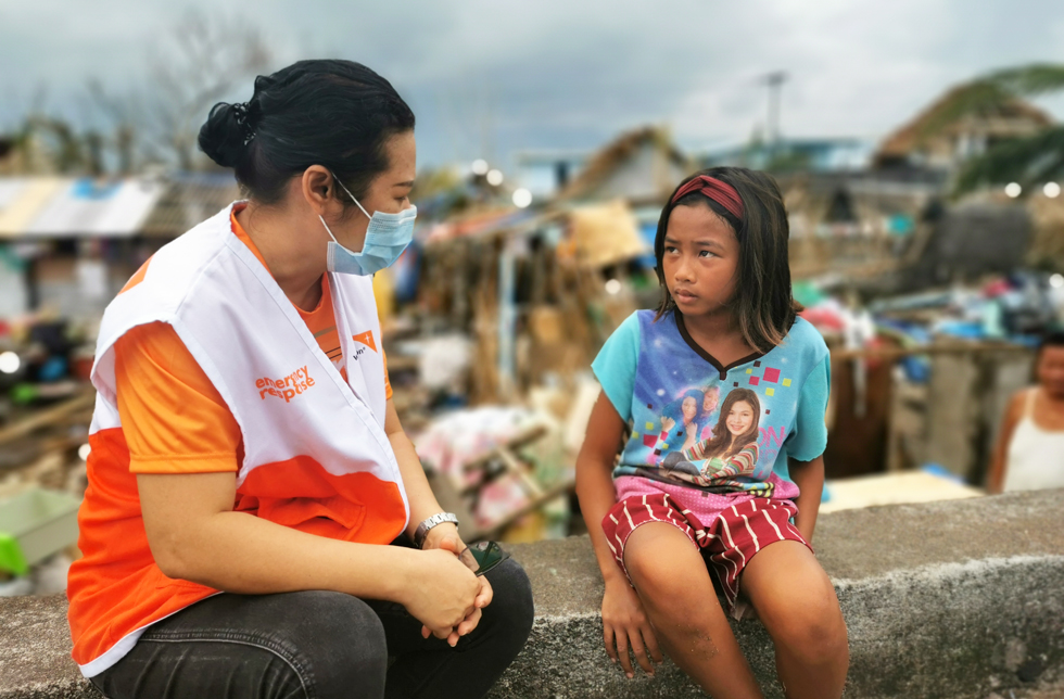 Philippinen: Ein Mädchen vertraut sich einer World Vision-Mitarbeiterin an.